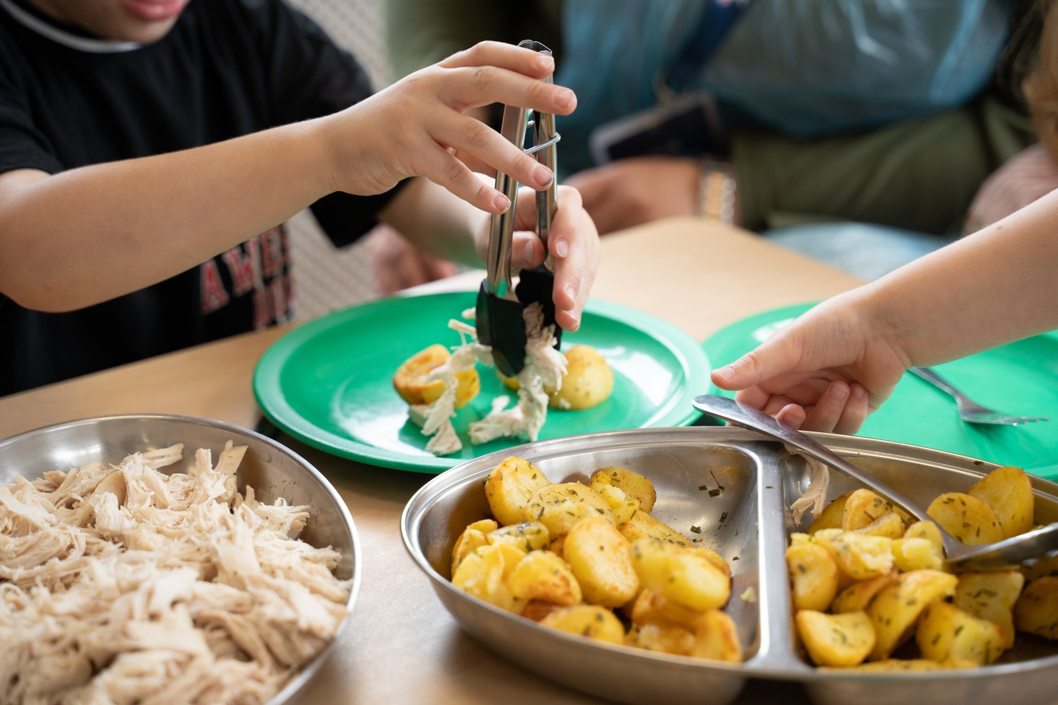 A child carefully cutting potatoes with a small knife at a nursery activity