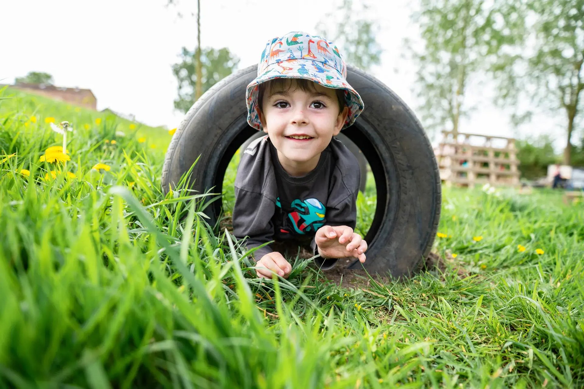 child-crawling-through-tyre-at-pippins-montessori-day-nursery-forest-school-colchester-2000x1333