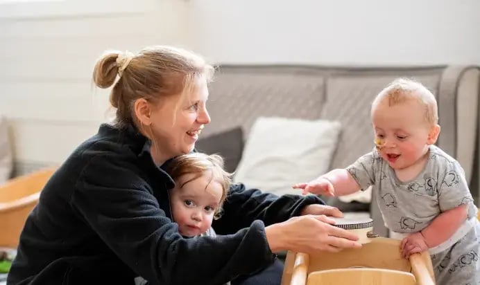 202307-key-worker-playing-with-tamberine-with-children-at-kiddi-caru-day-nursery-preschool-hanham-bristol-6