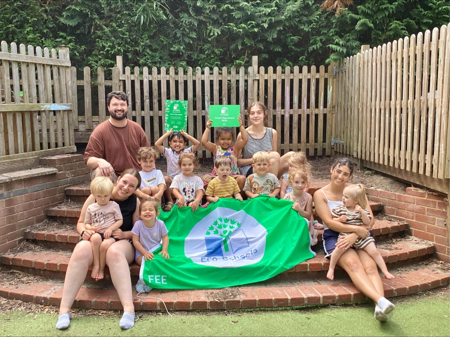 Kiddi Caru Walnut Tree children and staff holding 2026 Eco-School Green Flag