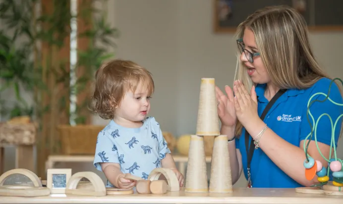 Child and key worker playing and clapping at Kiddi Caru Day Nursery Preschool Walnut Tree Milton Keynes