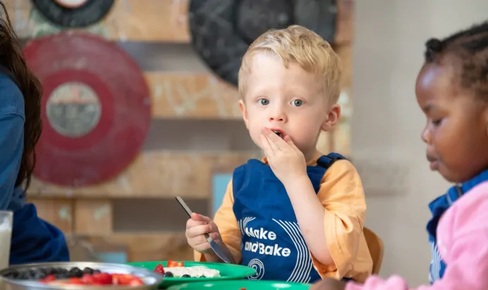 Child eating strawberries at Kiddi Caru Day Nursery Preschool Walnut Tree Milton Keynes