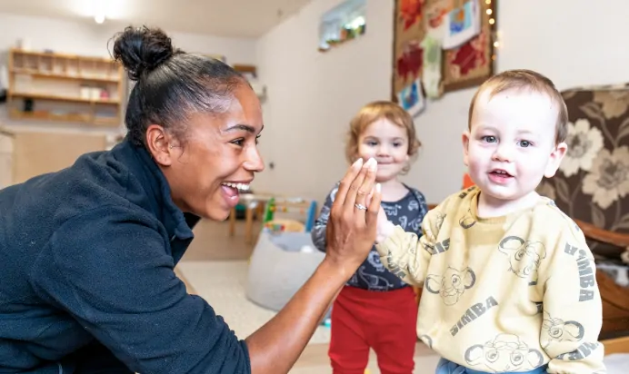 Child high fives key worker at Charnwood Day Nursery Preschool Shepshed Loughborough