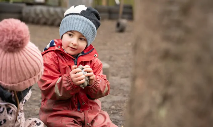 Child holding stones outside at The Melton Mowbray Day Nursery Preschool Leicester