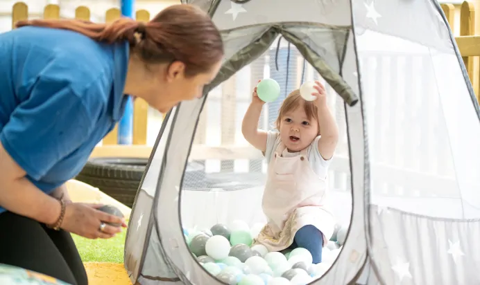 Child playing in ball pit at The Kiddi Caru Day Nursery Preschool Burgess Hill