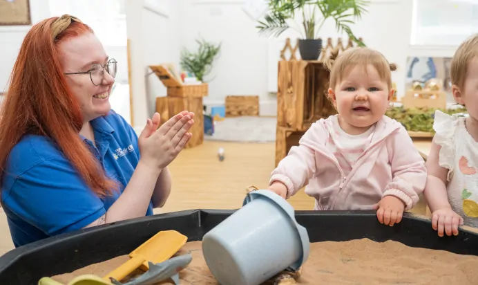Child playing with interactive sand pit at The Old Barn Day Nursery Preschool Narborough