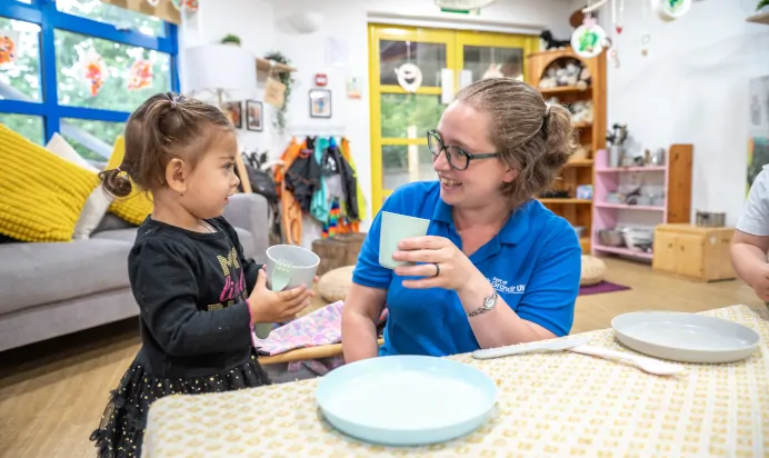 Child playing with key worker at The Kiddi Caru Day Nursery Preschool Burgess Hill