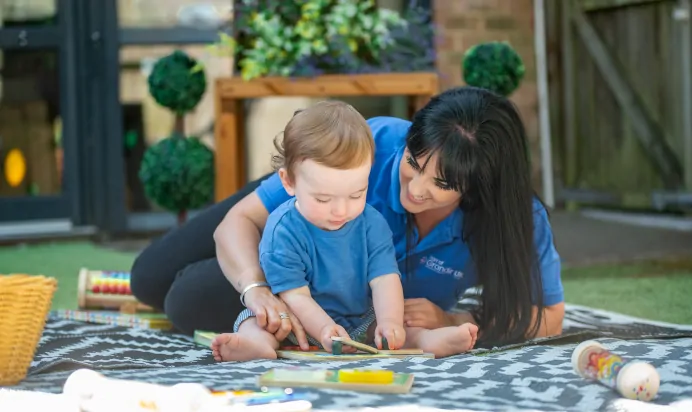 Child playing with key worker doing a puzzle at Kiddi Caru Day Nursery Preschool Whiteley