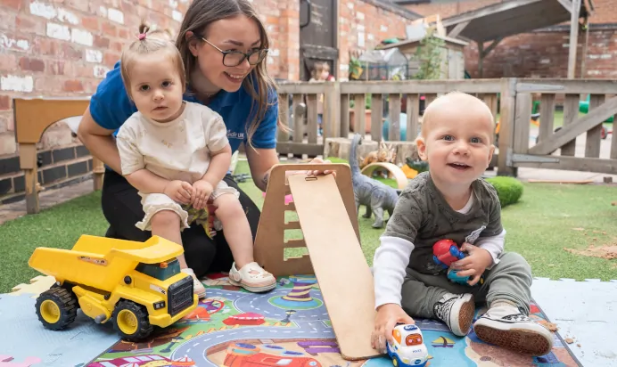 Child playing with keyworker in outside space at The Old Barn Day Nursery Preschool Narborough