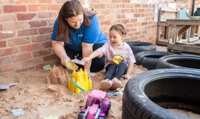 Child playing with sand pit at The Old Barn Day Nursery Preschool Narborough