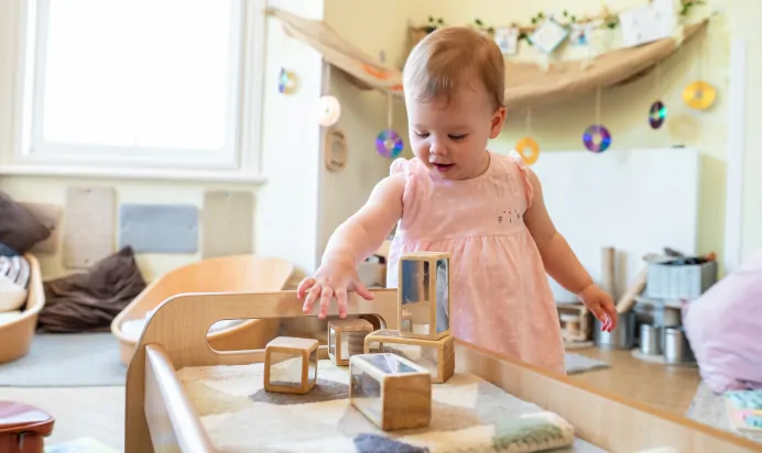 Child playing with wooden blocks at Kiddi Caru Day Nursery Preschool Leighton Buzzard