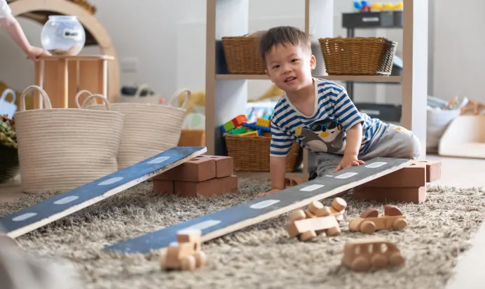 Child playing with wooden cars at Kiddi Caru Day Nursery Preschool Walnut Tree Milton Keynes