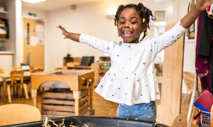 Child smiling inside at Kiddi Caru Day Nursery Preschool Peterborough