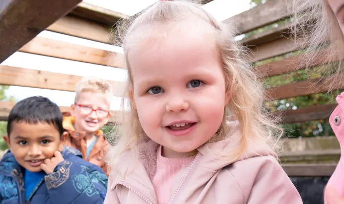 Child smiling towards camera at The Kiddi Caru Day Nursery Preschool Basingstoke