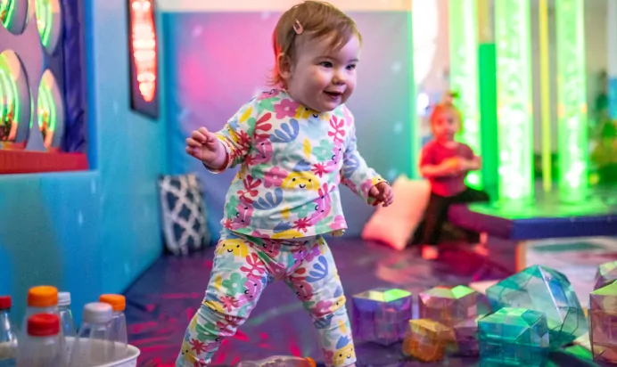 Child walking on soft mats with toys at Kiddi Caru Day Nursery Preschool Peterborough