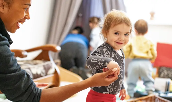 Child with key worker smiling to the camera at Charnwood Day Nursery Preschool Shepshed Loughborough