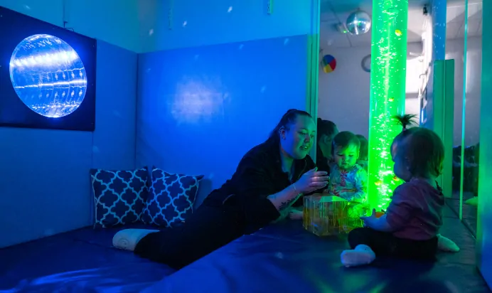 Children and key worker looking at tall fish lamp at Kiddi Caru Day Nursery Preschool Peterborough