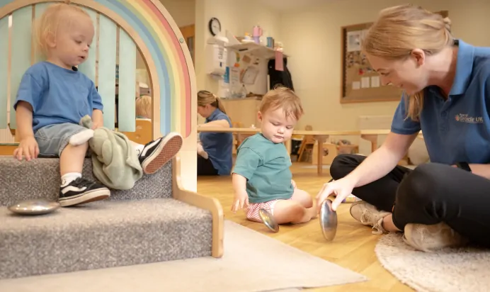 Children and key worker playing indoors at The Kiddi Caru Day Nursery Preschool Writtle