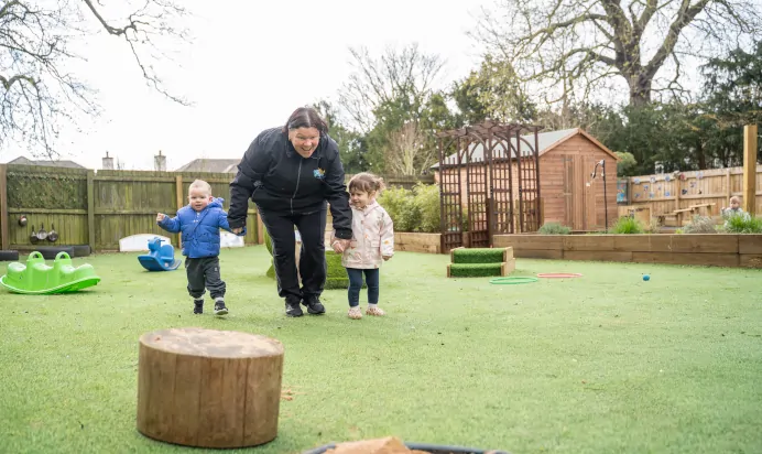 Children and keyworker running outside at The Melton Mowbray Day Nursery Preschool Leicester