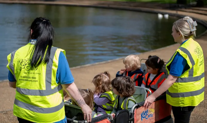 Children by pond with key workers at Kiddi Caru Day Nursery Preschool Caldecotte Milton Keynes