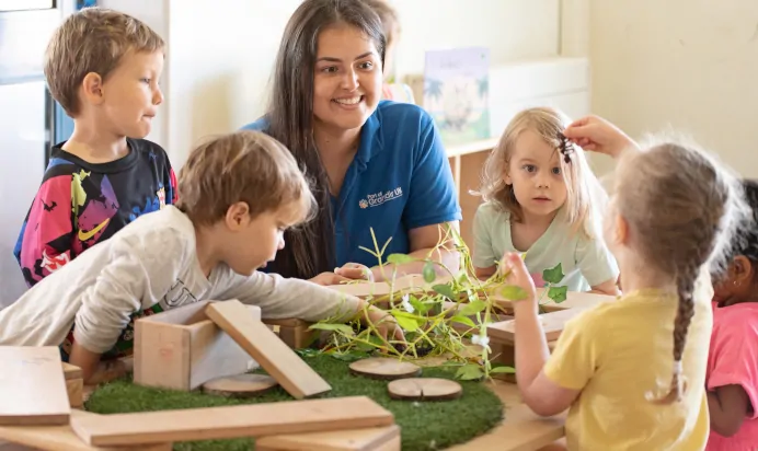 Children collaborating in interactive space with keyworker at The Kiddi Caru Day Nursery Preschool Taunton