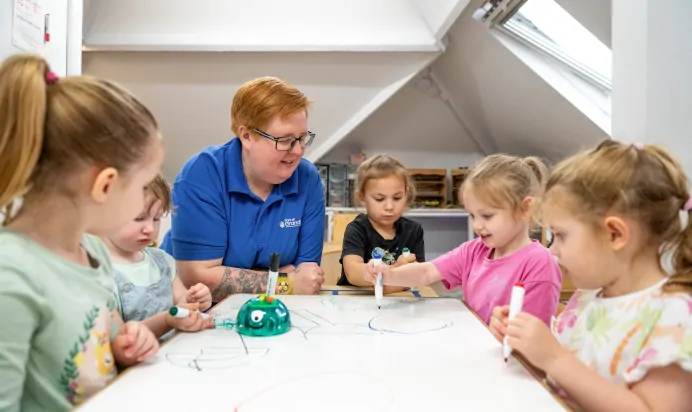 Children drawing on whiteboard with key worker at Charnwood Day Nursery Preschool Shepshed Loughborough