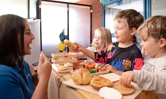 Children enjoying food with key worker at The Kiddi Caru Day Nursery Preschool Taunton