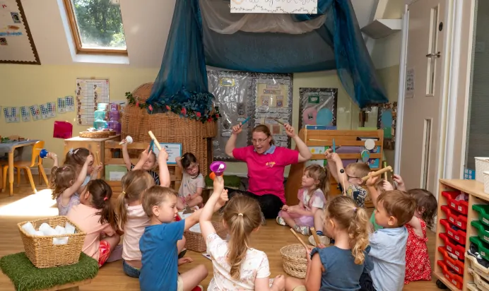 Children having circle time with muscial instruments at Kiddi Caru Day Nursery Preschool Whiteley