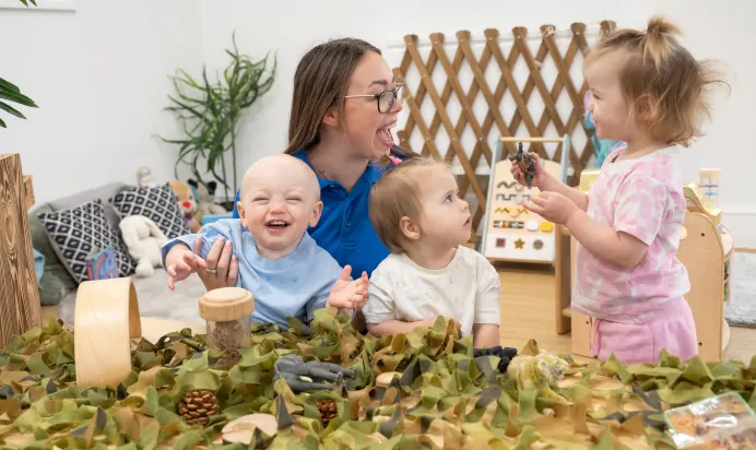 Children laughing with key worker in interactive space at The Old Barn Day Nursery Preschool Narborough