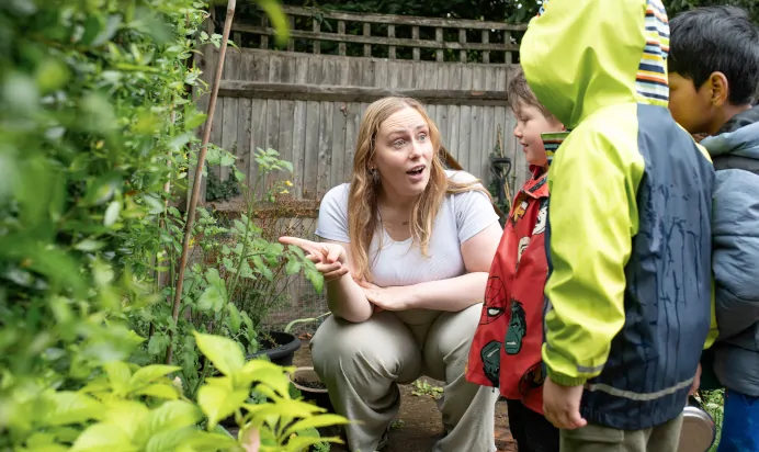 Children learning with key worker about plants at The Kiddi Caru Day Nursery Preschool Burgess Hill