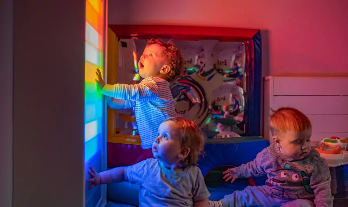 Children looking at colourful lights at Kiddi Caru Day Nursery Preschool Plympton Plymouth