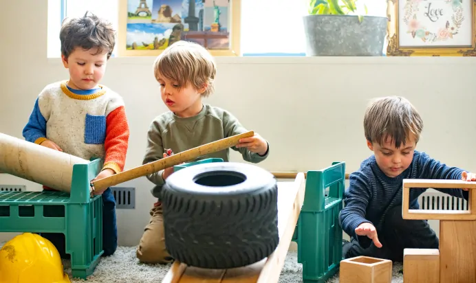 Children making car ramp with wood at Kiddi Caru Day Nursery Preschool Market Harborough