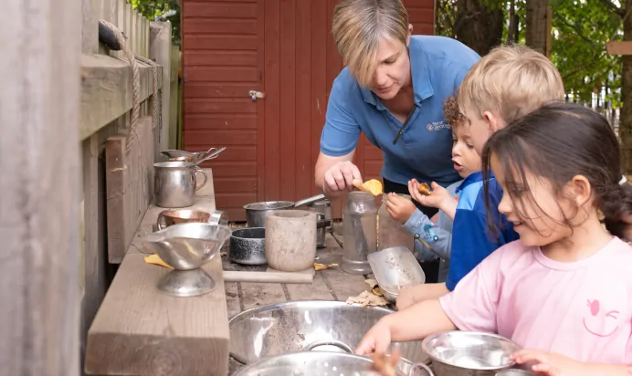 Children playing in outdoor play kitchen at The Kiddi Caru Day Nursery Preschool Writtle