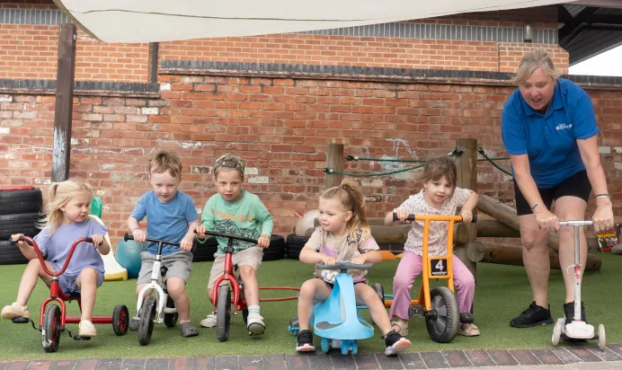 Children playing on tricycles at The Old Barn Day Nursery Preschool Narborough
