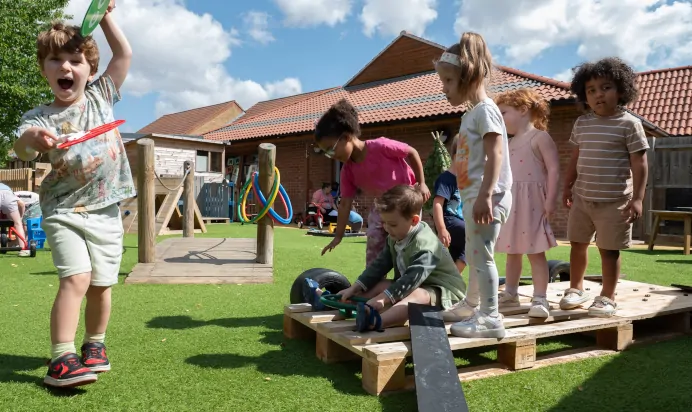 Children playing outdoors at Kiddi Caru Day Nursery Preschool Walnut Tree Milton Keynes