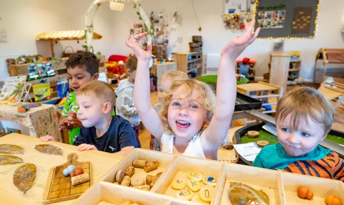 Children playing together inside smiling at Kiddi Caru Day Nursery Preschool Wellingborough