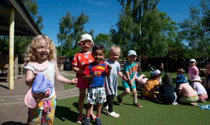 Children playing together outside at Kiddi Caru Day Nursery Preschool Wellingborough