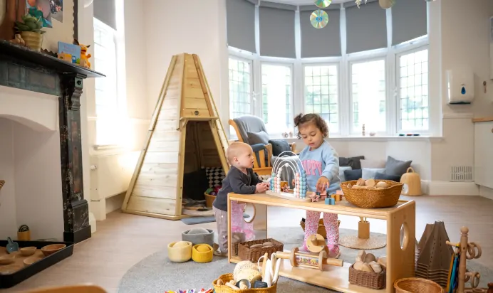 Children playing with abacus and wooden blocks on table at Little Acorns Day Nursery Preschool Stoneygate