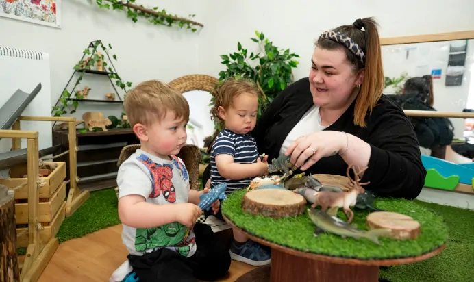 Children playing with animals inside with key worker at Kiddi Caru Day Nursery Preschool Abington Park Northampton