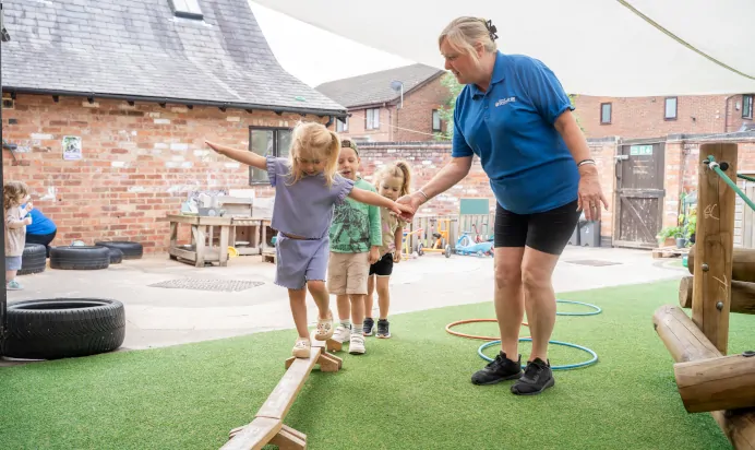 Child playing with keyworker in outside space at The Old Barn Day Nursery Preschool Narborough