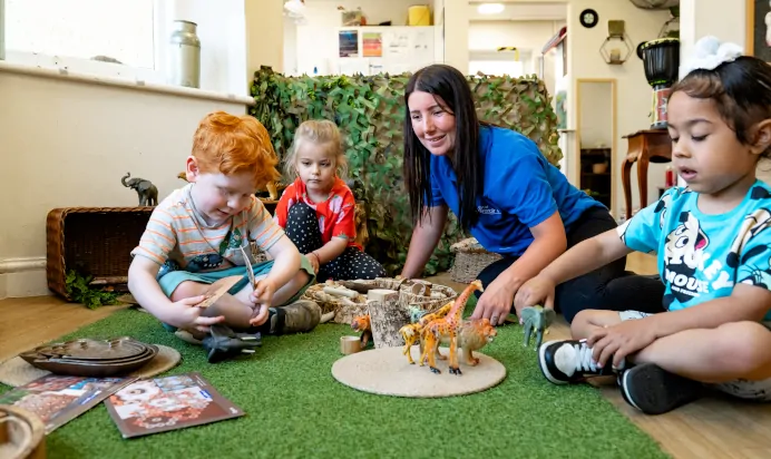 Children playing with key worker in interactive space at Kiddi Caru Day Nursery Preschool Abington Park Northampton