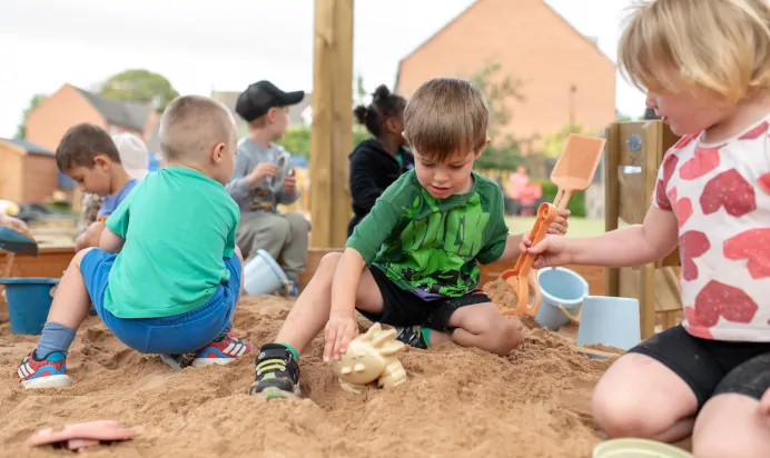 Children playing with sand pit at The Kiddi Caru Day Nursery Preschool Grange Park