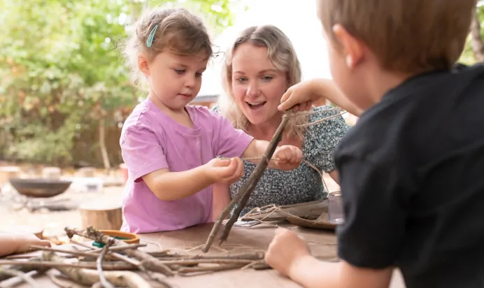 Children playing with sticks at The Kiddi Caru Day Nursery Preschool Writtle