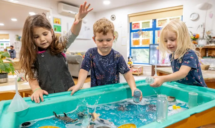 Children playing with water at The Kiddi Caru Day Nursery Preschool Burgess Hill