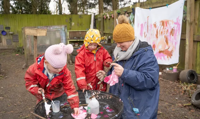 Children playing with water outside at The Melton Mowbray Day Nursery Preschool Leicester