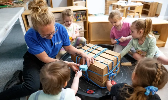 Children trying to unlock locks with colourful keys with key worker at Charnwood Day Nursery Preschool Shepshed Loughborough