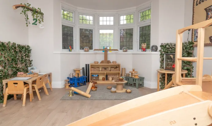 Indoor play space with table and slide at Little Acorns Day Nursery Preschool Stoneygate