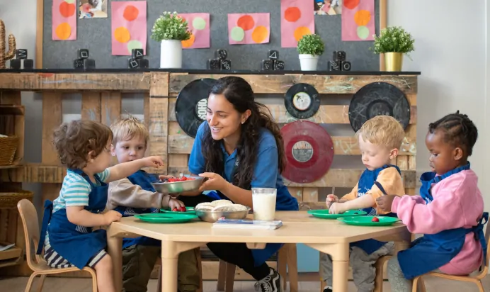 Key worker and children preparing food at Kiddi Caru Day Nursery Preschool Walnut Tree Milton Keynes