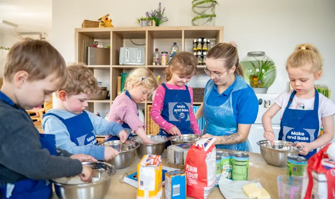 Key worker baking with children at Kiddi Caru Day Nursery Preschool Caldecotte Milton Keynes