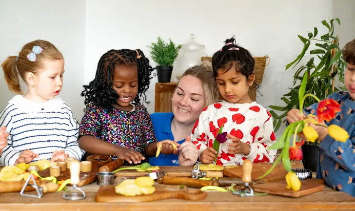 Key worker helping children at Kiddi Caru Day Nursery Preschool Caldecotte Milton Keynes